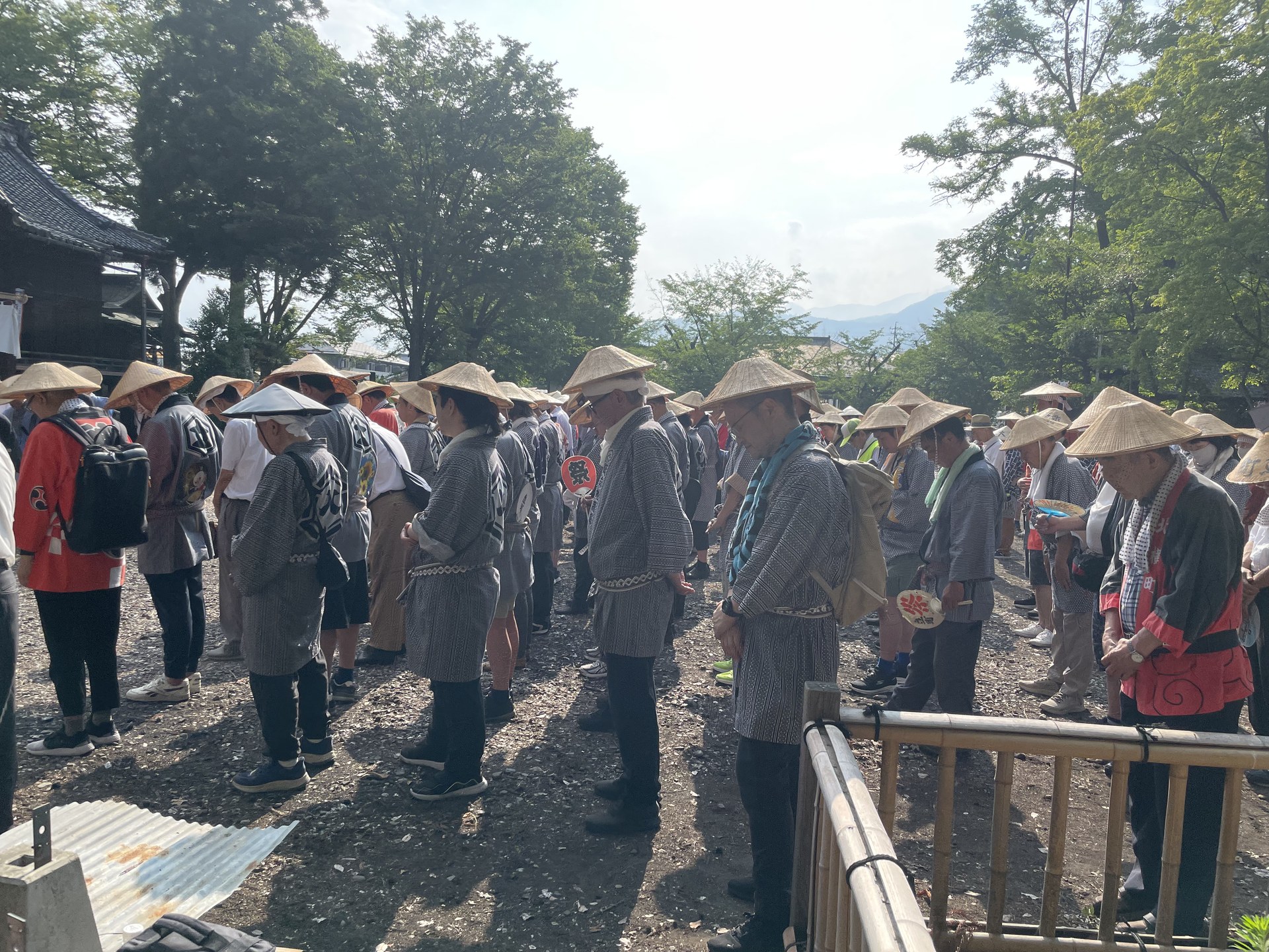 菅笠と揃いの装束で笠鉾巡行を待つ町の人々