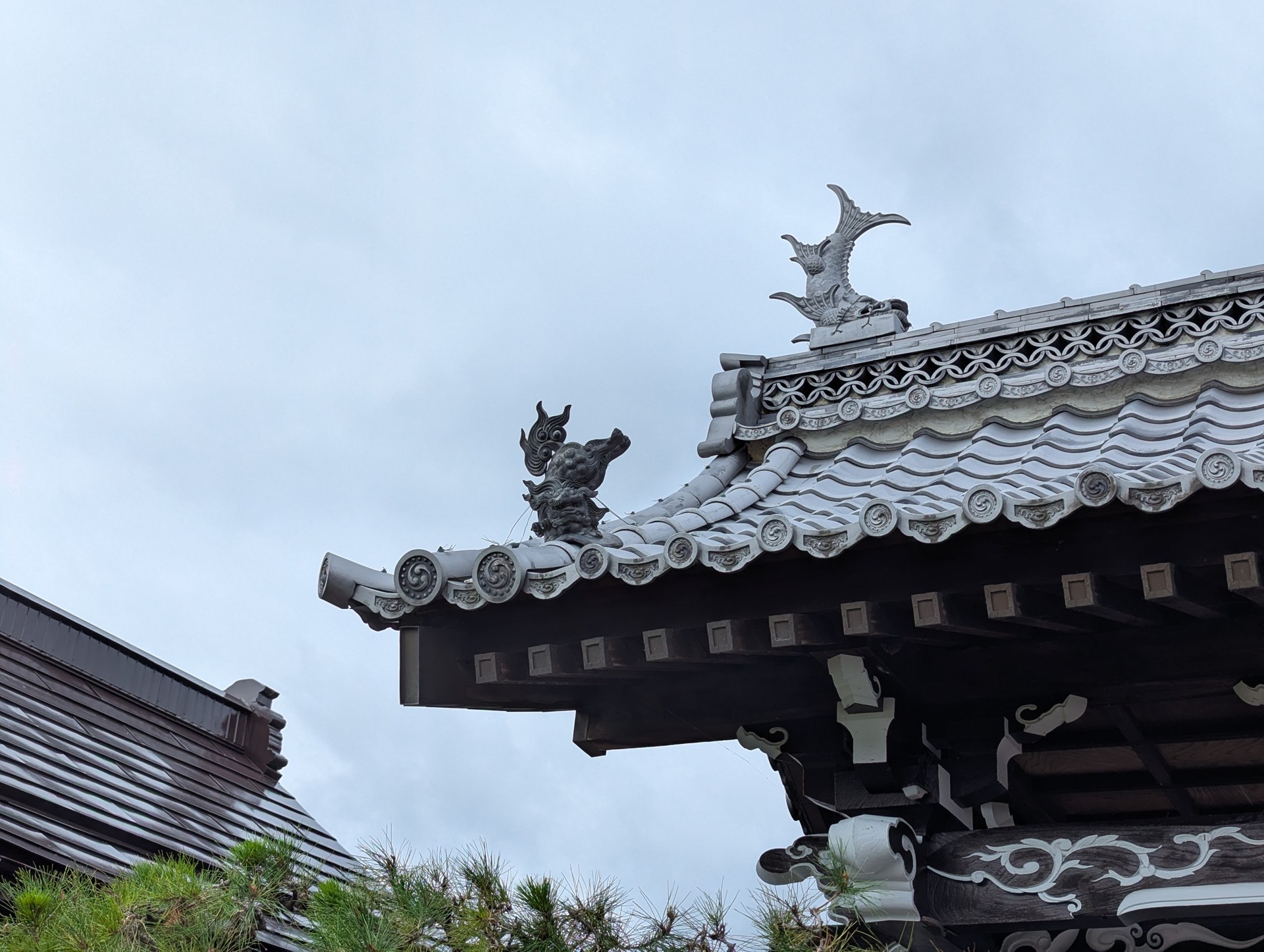 山門の屋根を彩る飾りと軒先の巴文様